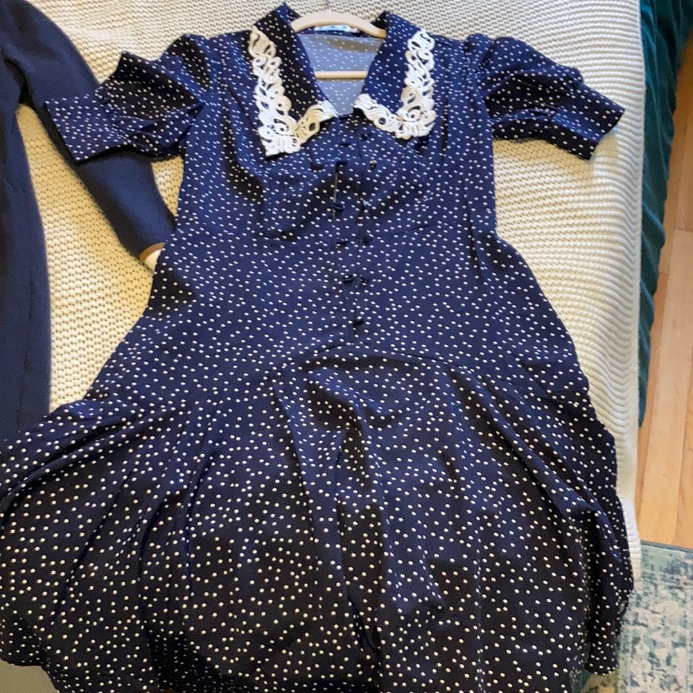 Knee length navy dress with white polka dots and embroidered collar.